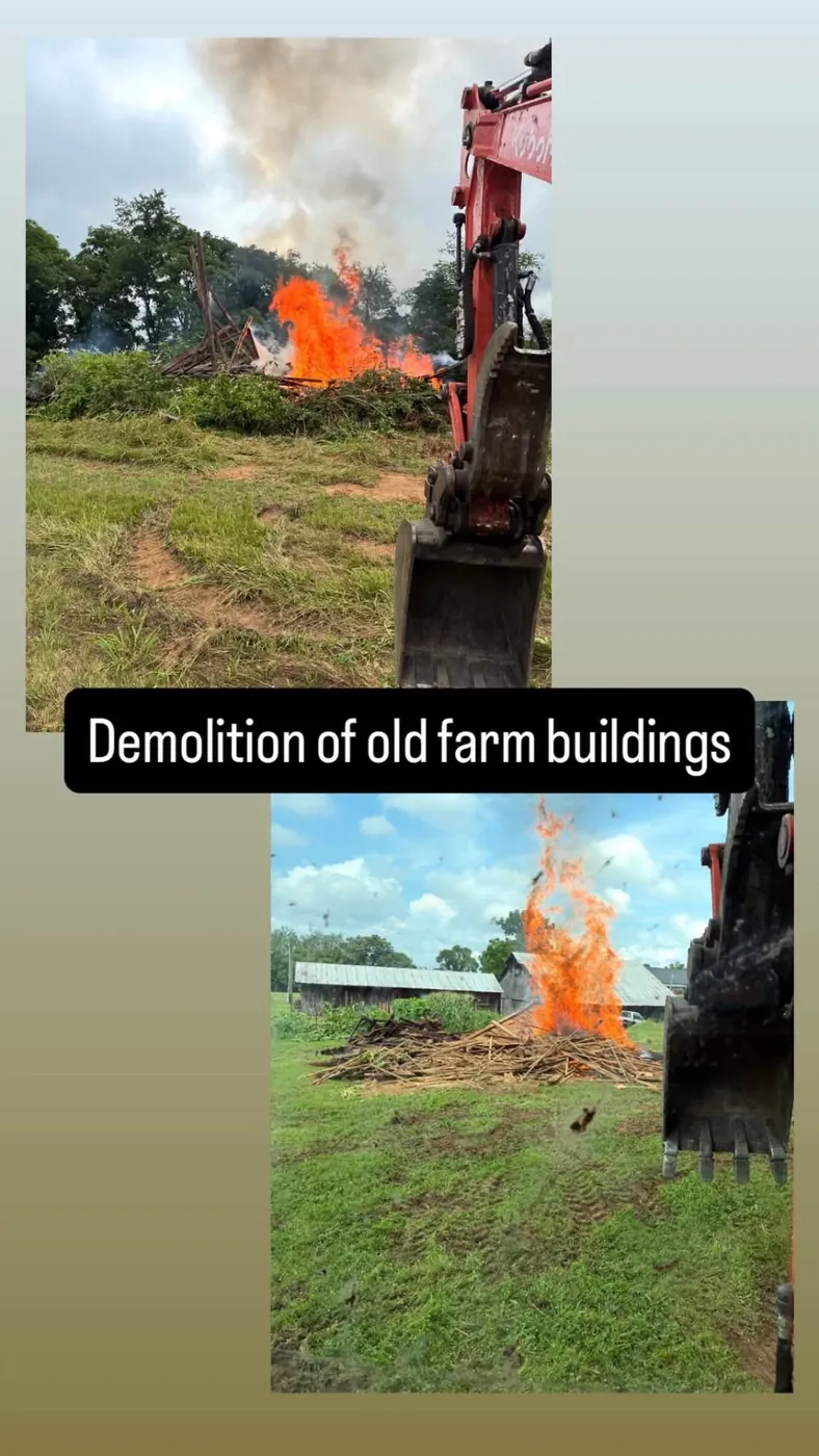 Excavator demolishing and burning off old farm buildings in East Tennessee